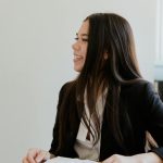 Portrait of a smiling businesswoman holding papers in a bright office setting.